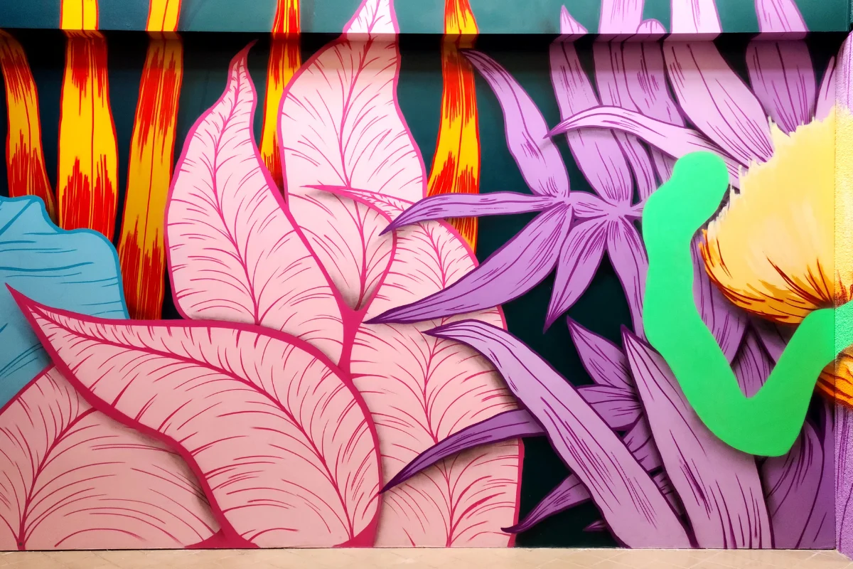 Mural de gran format amb fulles i flors de colors en una paret del Poblenou