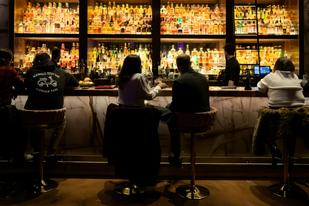 Barra d'un bar de l'Eixample amb plats de tapes i taps de cervesa sobre el marbre