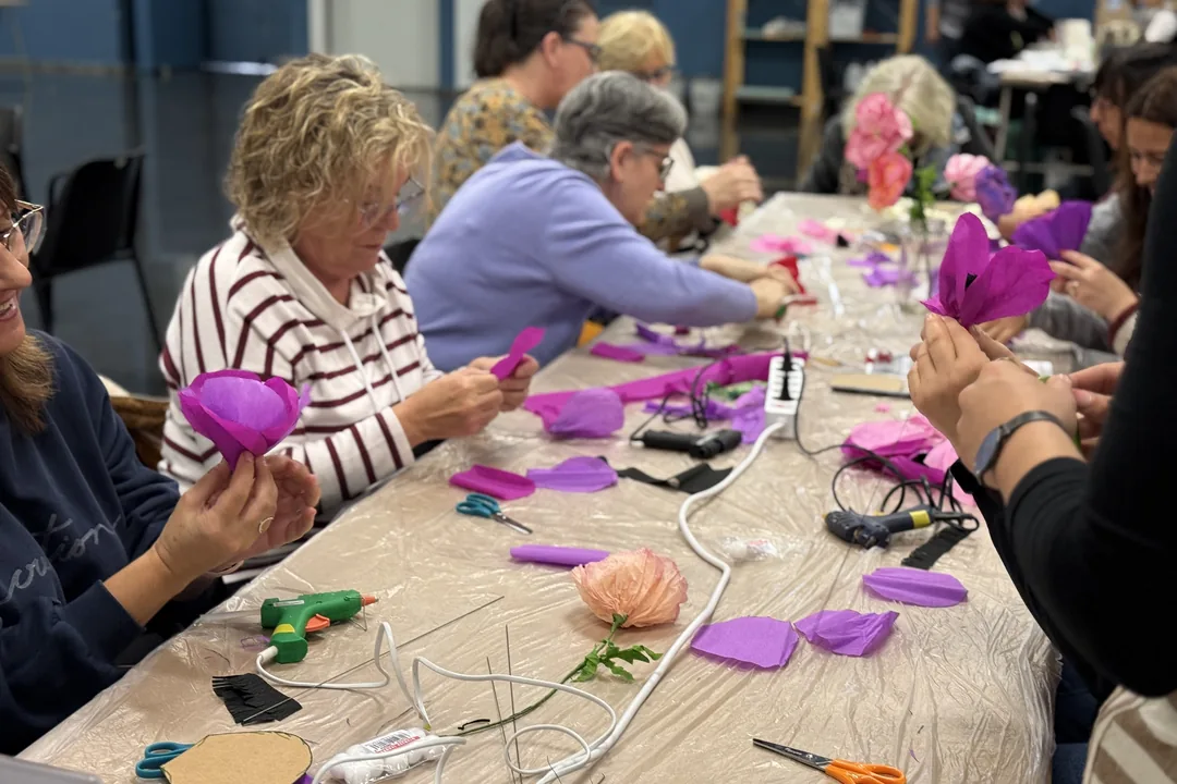 Grupo de participantes haciendo flores de goma eva en una mesa de taller de Creativa Barcelona