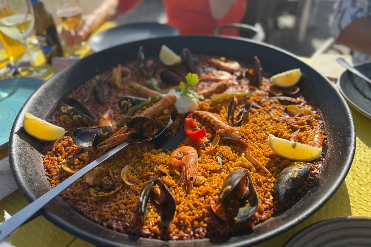 Arroz negro con sepia y alioli en paella de hierro en un restaurante de la Barceloneta de Barcelona