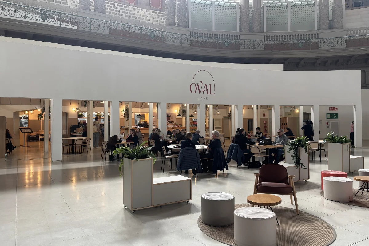 Oval Café inside MNAC Barcelona with visitors and the café logo visible in the oval hall