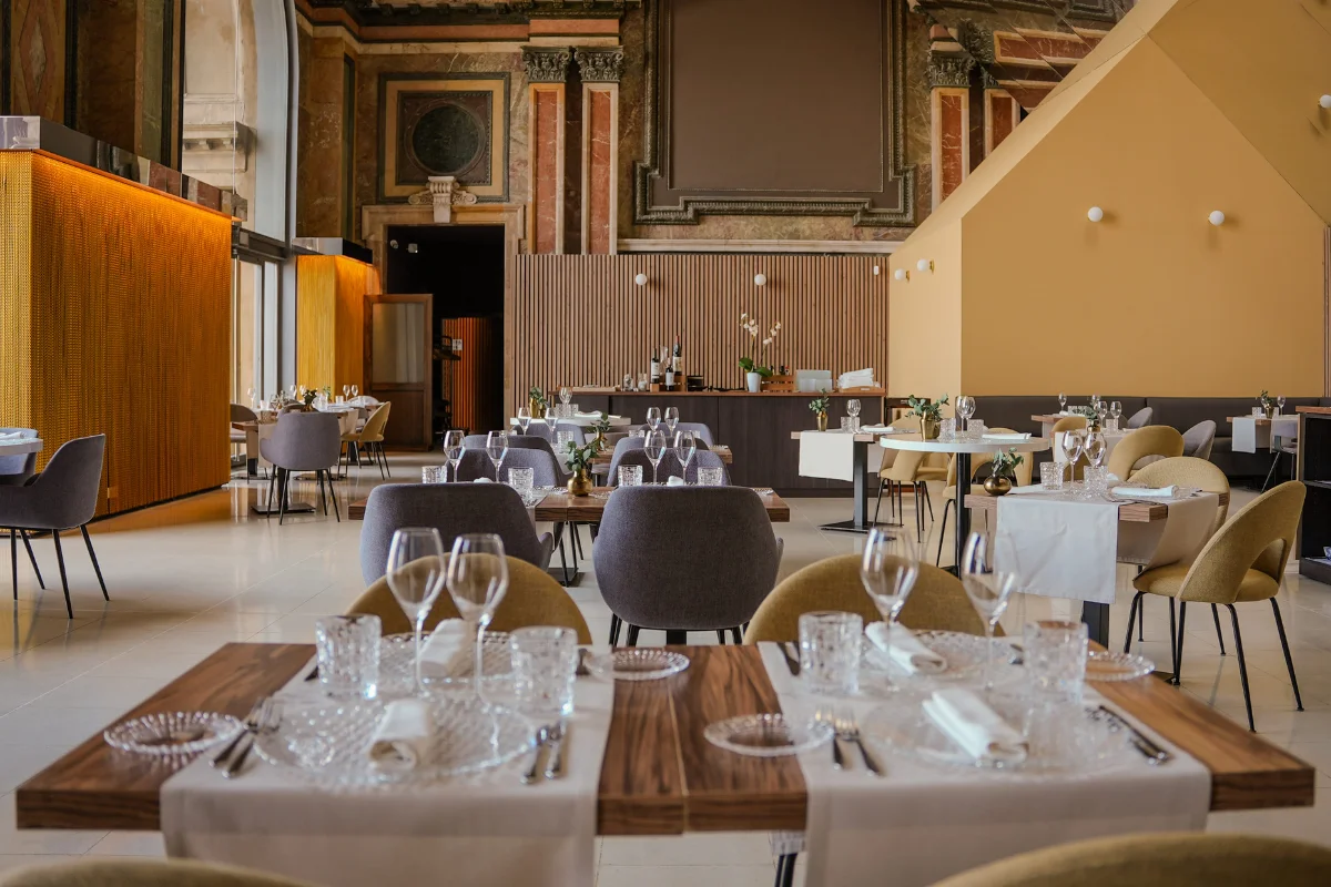Vista aérea del restaurante Absis en el interior del MNAC Barcelona con mesas preparadas e iluminación cálida